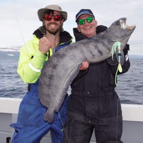 Zwei Angler präsentieren einen geangelten Fisch